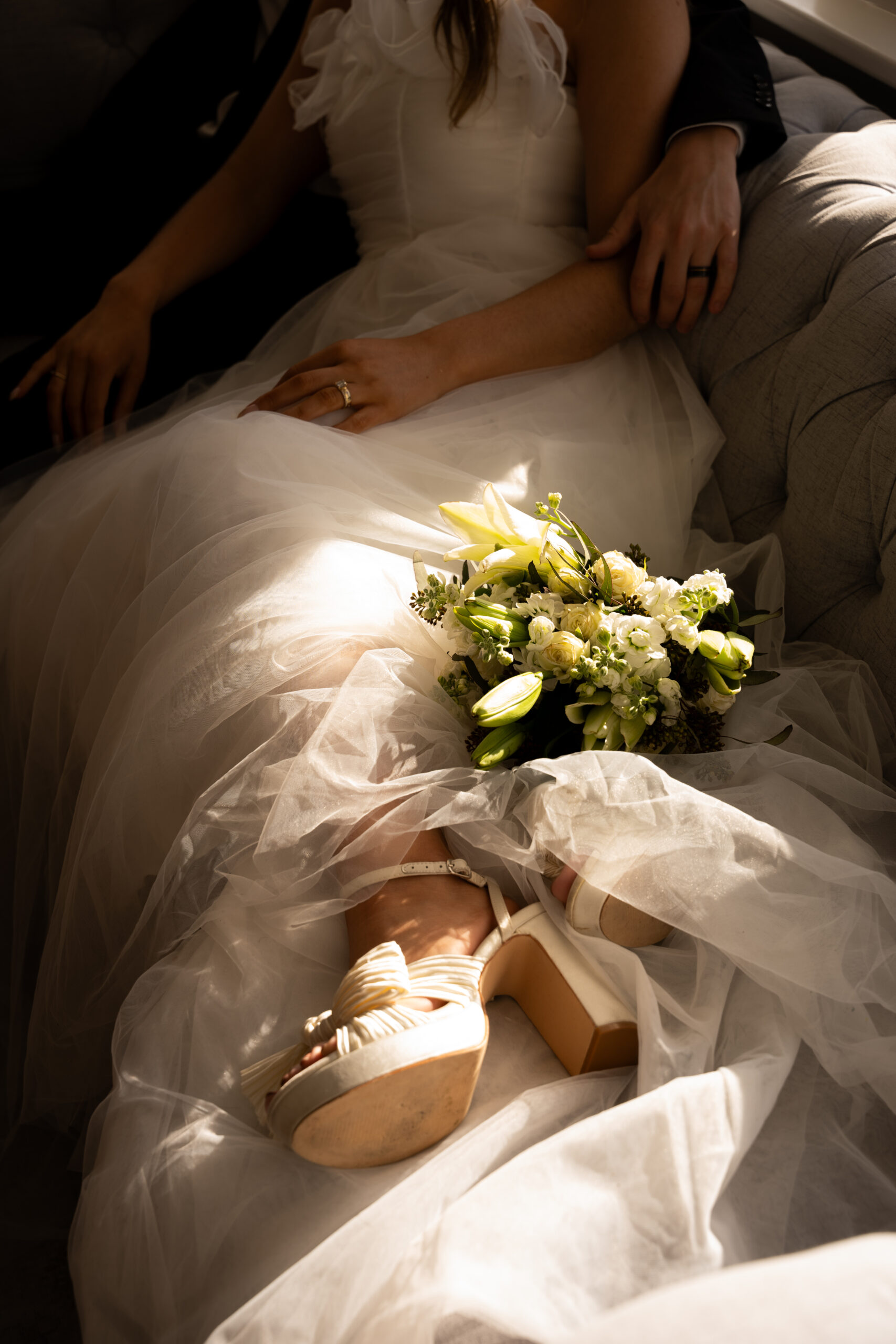 Wedding photo featuring a white bridal bouquet set on the bride's dress.